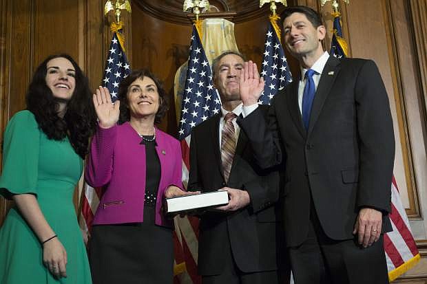 FILE - In this Jan. 3, 2017 file photo, House Speaker Paul Ryan, right, of Wisconsin, administers the House oath of office to Rep. Jacky Rosen, D-Nev., second from left, during a mock swearing in ceremony on Capitol Hill in Washington. Rosen said Wednesday, June 21, 2017, she will seek the Democratic nomination to take on incumbent Republican Sen. Dean Heller in the 2018 election. (AP Photo/Zach Gibson, file)