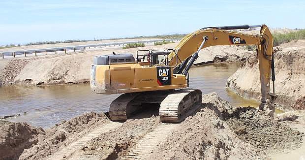 An excavator removes a piece of dirt to allow water to flow in the &quot;Big Dig&quot; channel.