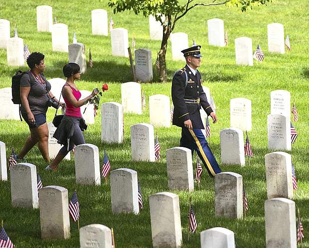 Visitors walk among the graves at Arlington National Cemetery.