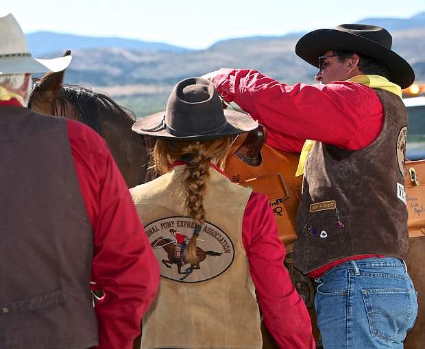 Dwight Borges attaches the mochila to Veronica Jenks&#039; horse &#039;Bretta&#039; during the 2016 Pony Express Re-ride..