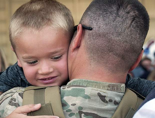Sgt. 1st Class Kevin Vogt hugs his 6-year-old son Gavin during the unit&#039;s deployment return from Kuwait at Atlantic Aviation in Reno Thursday.