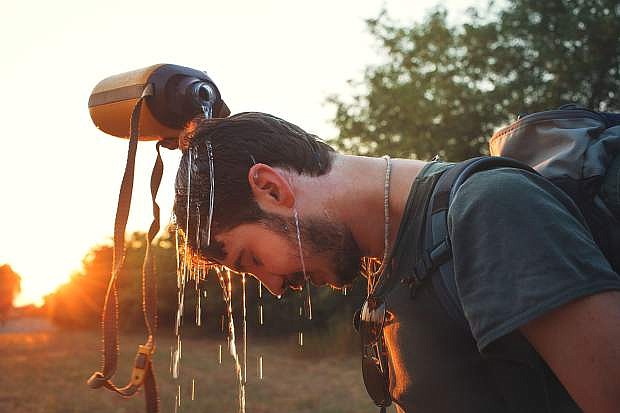 hiker Man dropping fresh water on his head