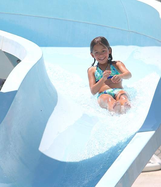 Melissa True, 8, is all smiles as she takes a refreshing ride on the water slide at the Carson City Aquatic Center on Monday.