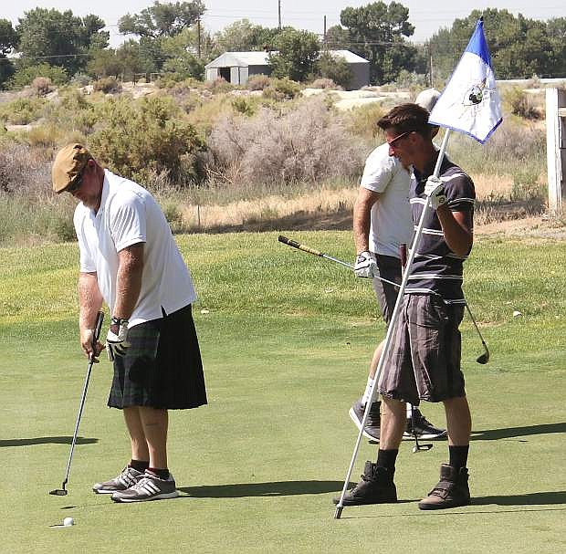Moward, left, and Dustin Cantrell putt out on a hole at Fallon Golf Course.