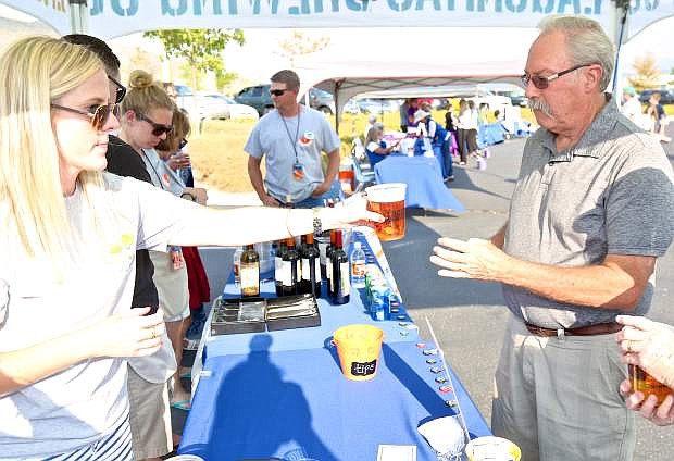 Adrienne Phenix of Remax Realty hands Dan Egle of Carson City a beer at last year&#039;s HopeFest.