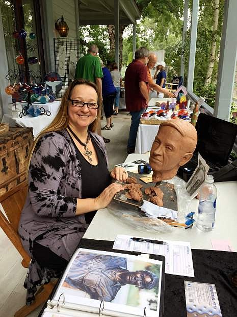 Sculptor Mischell Riley creates art on the Bliss Mansion porch at the Jazz &amp; Beyond Festival opening event last year.