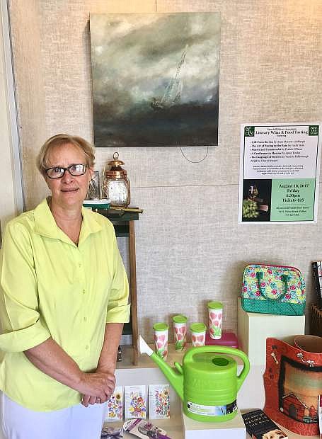 Library Director Carol Lloyd stands next to a display featuring some of the items associated with different works of literature. The annual Literary Wine and Food Tasting is at 6:30 p.m. on Friday, Aug. 18. Tickets are available for $25 each at the library.