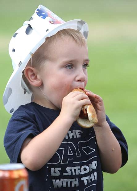 Wyatt Hogan, 3, enjoys a free hot dog and cold drink at the National Night Out event on Tuesday.
