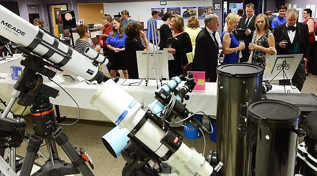 Western Nevada College Foundation supporters check out the silent auction at the Reach for the Stars academic fundraiser held at Jack C. Davis Observatory on Saturday, Aug. 20, 2016.