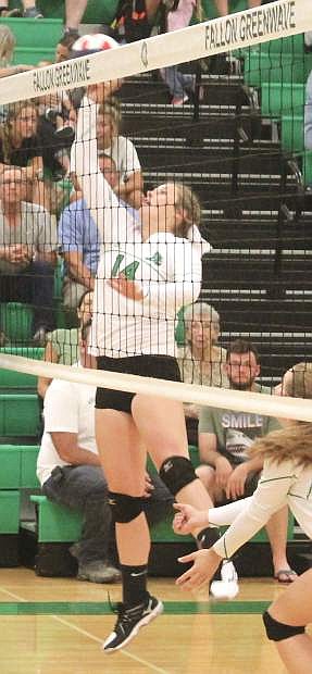 Macie Anderson leaps to block the ball at the net.
