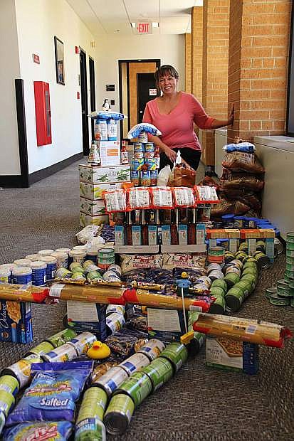 Debbie Blake from the U.S. Bureau of Reclamation shows off the dam of food the agency built out of donated food during the 2015 Feds Feed Families Food Drive.