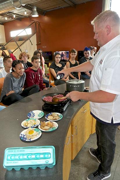 Clint Jolly adds salt to his Loco Moco recipe Wednesday at the Boys &amp; Girls Club.