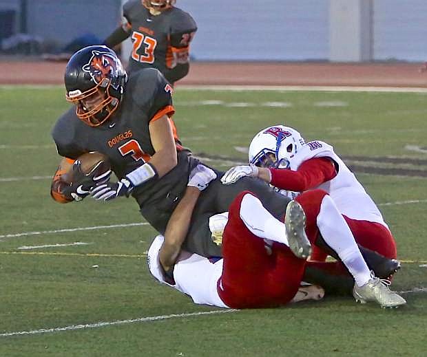Douglas receiver Devon Ryan (3) is taken down by a pair of Reno defenders Friday night in a 43-0 loss at home.