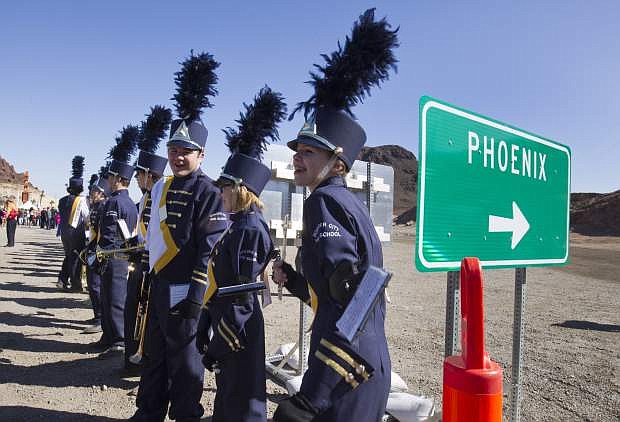 Piccolo player Grace Priest, right, and other members of the Boulder City High School marching band, wait for the start of a groundbreaking ceremony for the Interstate-11/Boulder City Bypass project near Boulder City, Monday, April 6, 2015. The $318 million project is expected to be completed in 2018 and create about 4,000 jobs. (Steve Marcus/Las Vegas Sun via AP)