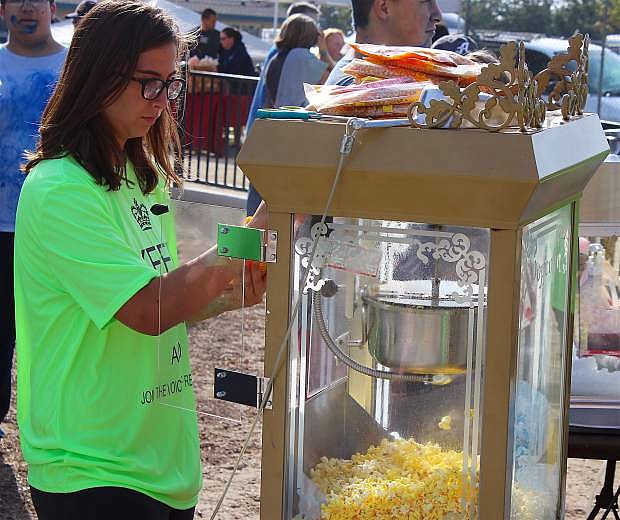 JROTC member and volunteer Kailey Freeman, a freshman at Churchill County High School, helps ready the group&#039;s popcorn machine. The JROTC students have helped before and also assisted with the color blast run. &quot;I love this,&quot; Freeman said of the event.