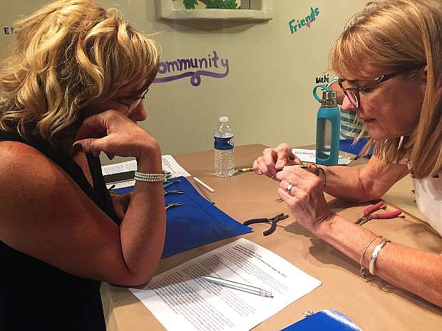 Jo Ann Grace, right, teaches Sheri Dunn how to wrap wire during a jewelry-making class at the Artsy Fartsy Art Gallery.