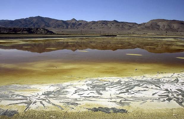 FILE - In this Nov. 30, 2004, file photo, an evaporation pond holds contaminated fluid and sediment at the former Anaconda copper mine near Yerington, Nev. Nevada wants to back out of an agreement with U.S. regulators to designate the toxic mine as a priority Superfund site, a move critics say could ultimately leave state taxpayers on the hook for hundreds of millions dollars in cleanup costs at the abandoned World War II-era copper mine near Yerington, according to documents obtained by The Associated Press. (AP Photo/Debra Reid, File)