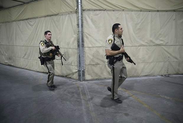 Police officers enter the Mandalay Bay resort and casino during a shooting near the Mandalay Bay resort and casino on the Las Vegas Strip, Sunday, Oct. 1, 2017, in Las Vegas. (AP Photo/John Locher)