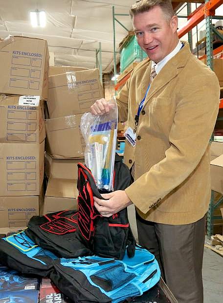 Carson City School Disrict Public Information Officer Dan Davis loads a backpack for the McKinney-Vento program Thursday at the district office.