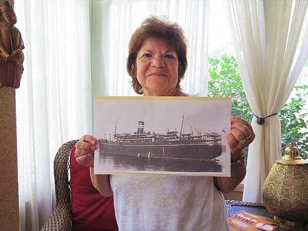 Janet Sidoti Delude, daughter of U.S. Army Staff Sgt. Peter J. Sidoti, who was rescued from the stricken troopship Rohna, holds a photo of the ship taken two or three years before it was sunk by a German glider bomb nearly 75 years ago during World War II.