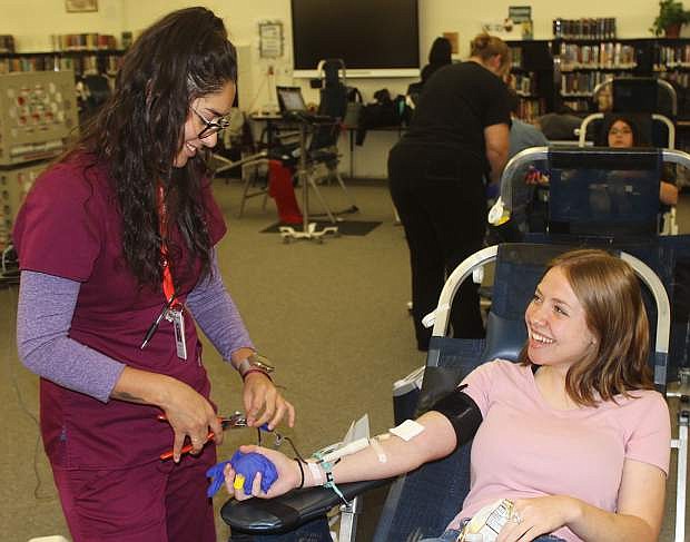 United Blood Service technician Raelena Valenzuela, left, prepares Churchill County High School student Angelina Mattern to give blood Wednesday morning.