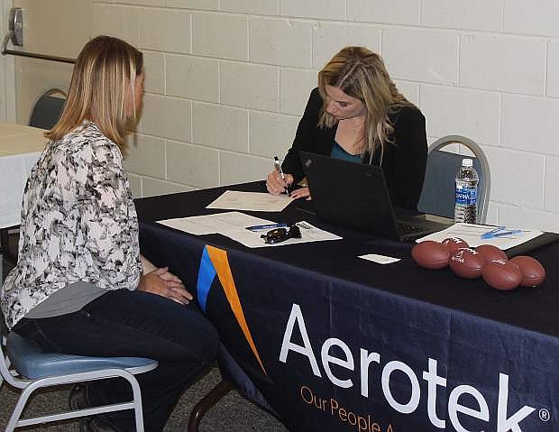 Karen Isbister, right, of Aerotek, a Reno staffing and recruiting firm, writes down information from an interested job seeker.