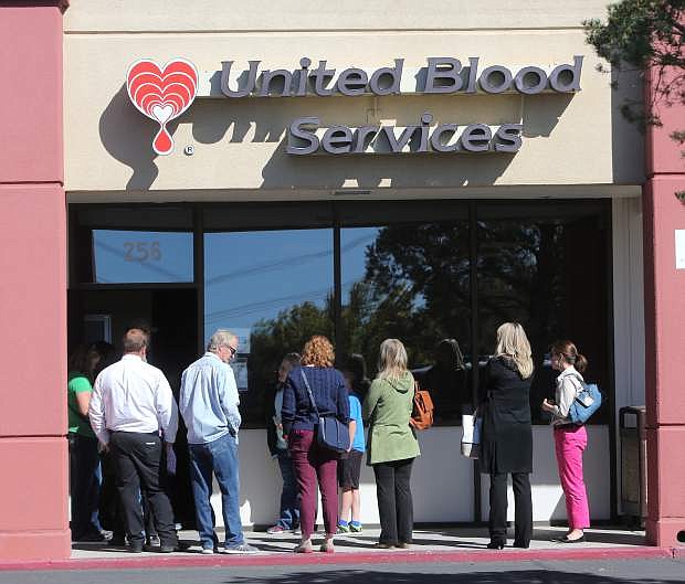 The waiting line to give blood streches outside the front door of United Blood Services and onto the sidewalk Monday morning as community members pack the facility to help victims of the Las Vegas shooting.