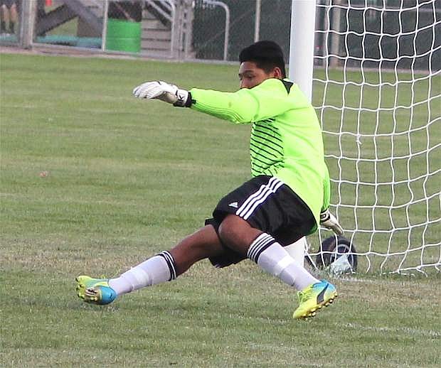 Goalkeeper Cesar Molina dives to stop the ball during a Greenwave home soccer match.