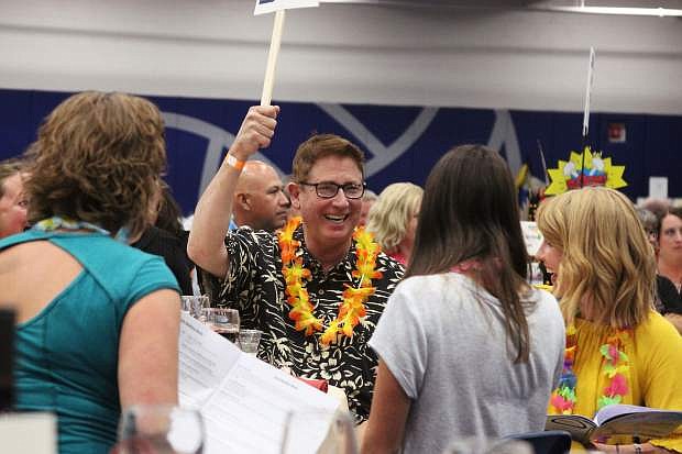Bill Calhoun raises a paddle during the live auction, one of the most popular and enduring events at the Boys &amp; Girls Clubs of Western Nevada Luau each year. The live auction portion of the event raised well over $60,000 this year.