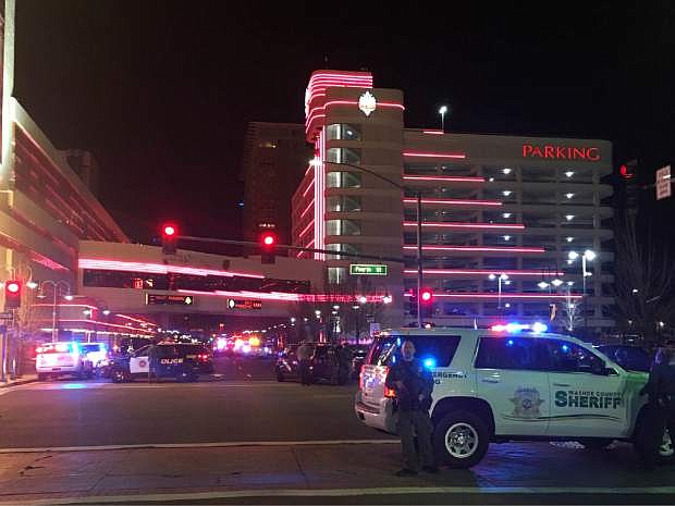 Police respond to an active shooter at a high-rise building of luxury condominiums in Reno, Nev., Tuesday, Nov. 28, 2017. A suspect is in custody after opening fire for at least 20 minutes Tuesday night, but there are no reports of any injuries, authorities said. The shots were fired at the Montage, a building in downtown Reno where SWAT teams and news vans have gathered. (Andy Barron/The Reno Gazette-Journal via AP)
