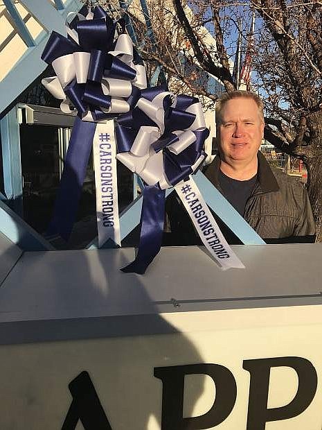 Carson Flag Store co-owner David Smith poses with two #CarsonStrong bows now displayed on the Nevada Appeal sign. Carson Flag Store is now offering the bows for $10 each with 100 percent of the proceeds going to the seven local high schools students injured in a recent crash. The bows are available at the store from 8:30 a.m. to 5 p.m. Monday through Friday at 3688 Reseach Way. Those who purchase the bows are encouraged to hang them at their businesses and homes. The store is also looking for volunteers to help make the bows. Those willing to help should call the store, 841-6227.
