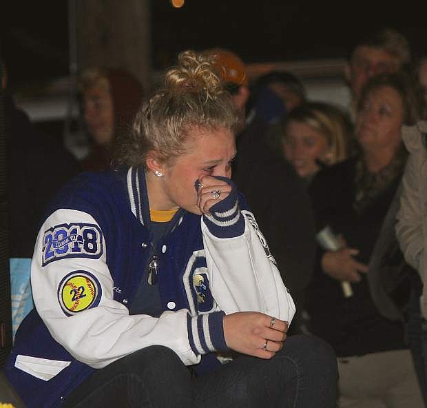 Carson High student Lauren Lemburg wipes away tears at the candlelight vigil Sunday night.