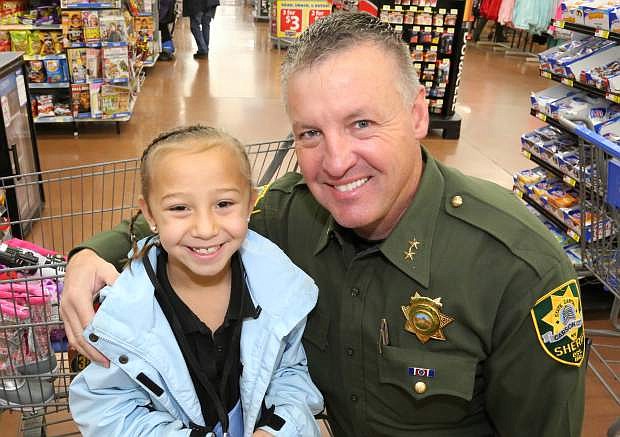Ken Sandage and 6-year-old Zakiah are all smiles at the annual Holiday with a Hero event last year at Walmart. Sandage is taking over as Carson City&#039;s Undersheriff.