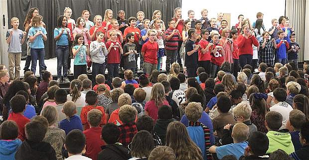 Numa&#039;s 5th-grade choir sings &quot;This Land is Your Land&quot; for their classmates and guests during the Veterans&#039; Day assembly.