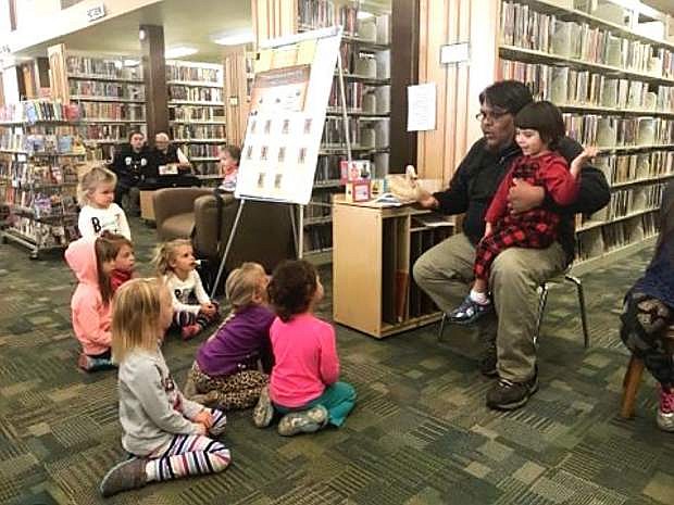 Local artist and member of the Fallon Paiute-Shoshone Tribe Joe Allen showcases his handmade decoy duck to children Wednesday at the Churchill County Library for National Native American Heritage Month.