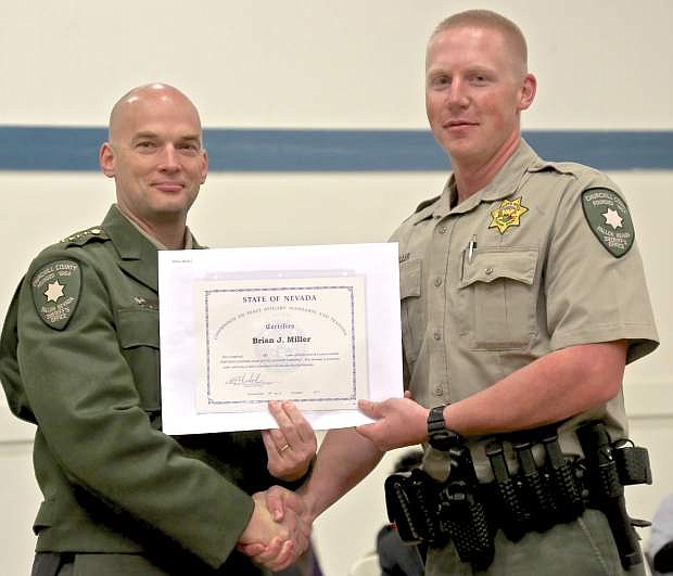 Sheriff Benjamin Trotter presents new Churchill County Deputy Brian J. Miller with his POST graduation certificate Thursday in Carson City.