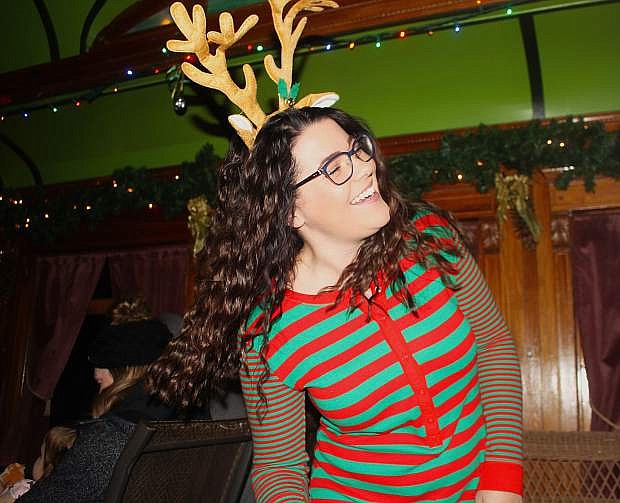 Clad in pajamas and reindeer antlers, Kenzie Bales sings Christmas carols aboard the Polar Express.
