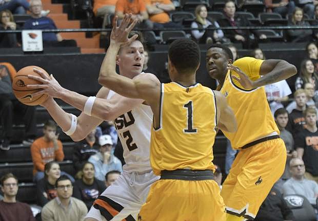 Oregon State&#039;s Drew Eubanks looks for an open teammate as Wyoming&#039;s Justin James (1) and a teammate defend during Monday&#039;s game in Corvallis, Ore. Wyoming won, 75-66.