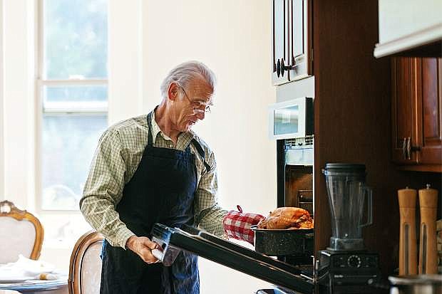 Single senior man cooking turkey