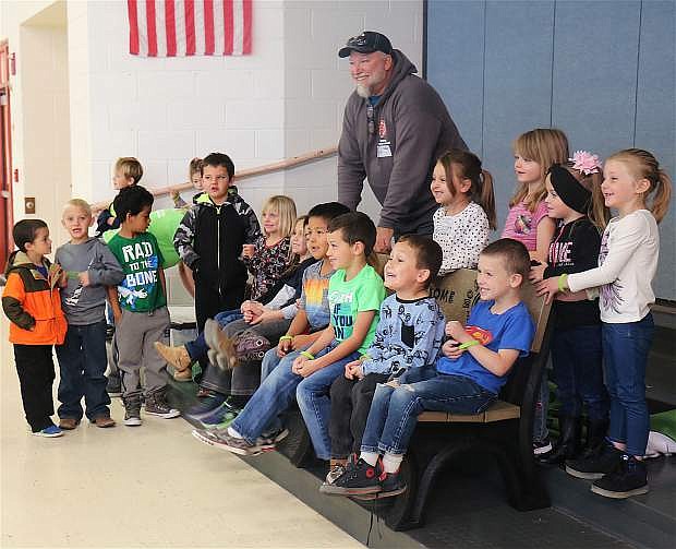 Lahontan Elementary School students gather around the Buddy Bench with Fallon&#039;s Pizza Factory owner, Eric Lombardi, after its unvieling Thursday morning.