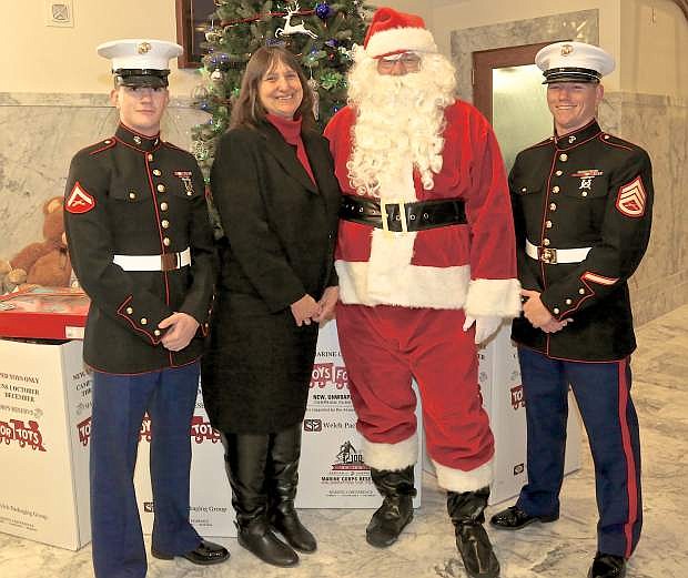(Left to Right)USMC Lance Corporal Logan Paschall, area Toys for Tots Director Joyce Buckingham, Santa and USMC SSG Jack Zellner pose for a photo on toy pick-up day at the State Capitol Thursday.