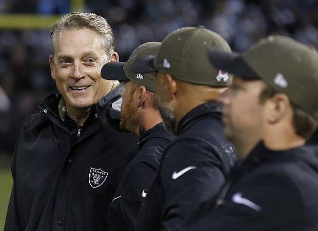 Oakland Raiders head coach Jack Del Rio, left, smiles as he talks to assistants during the second half of a game against the Denver Broncos on Nov. 26.