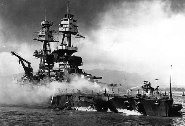 Navy fireboats battle flames aboard the USS Nevada after it received several direct hits from Japanese torpedo planes on Dec. 7, 1941.