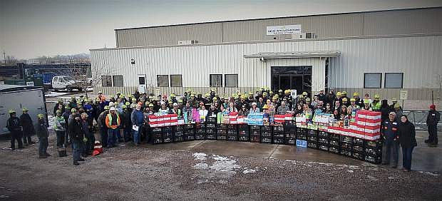 New Millennium Building Systems employees show off the wealth of their donations made to Out of Egypt Food Pantry in Fallon. The employees collected approximately 5,064 items along with $1,840 in gift cards for the pantry.
