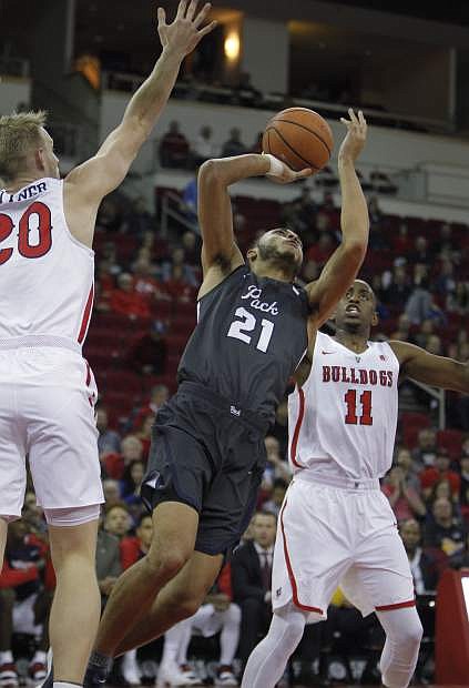 Nevada&#039;s Kendall Stephens puts up a shot over Fresno State&#039;s Sam Bittner, left and Bryson Williams during the first half of an NCAA college basketball game in Fresno, Calif., Wednesday, Dec. 27, 2017. (AP Photo/Gary Kazanjian)