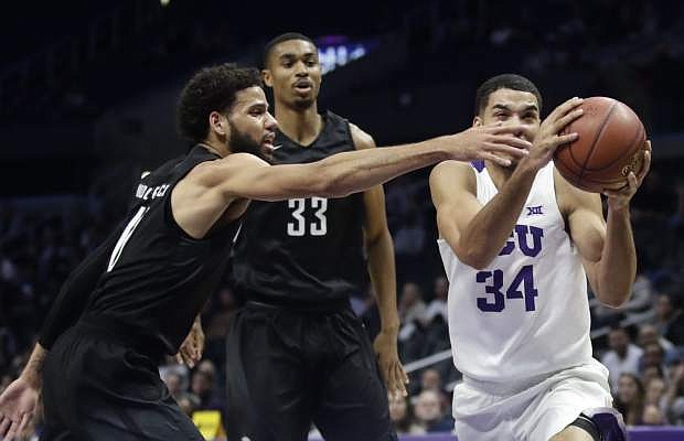 TCU guard Kenrich Williams, right, drives to the basket past Nevada forward Cody Martin, left, during the first half of an NCAA college basketball game in Los Angeles, Friday, Dec. 8, 2017. (AP Photo/Chris Carlson)