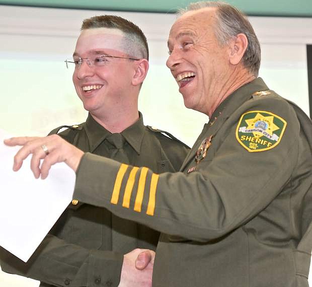 Deputy Jim LaChew shares a laugh with Sheriff Ken Furlong at his swearing in Thursday.