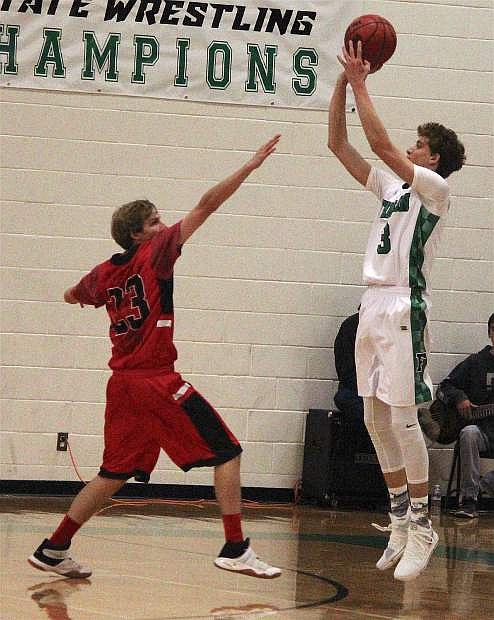 Hayden Strasden takes a shot on the basket over the head of one of Pershing County&#039;s players.