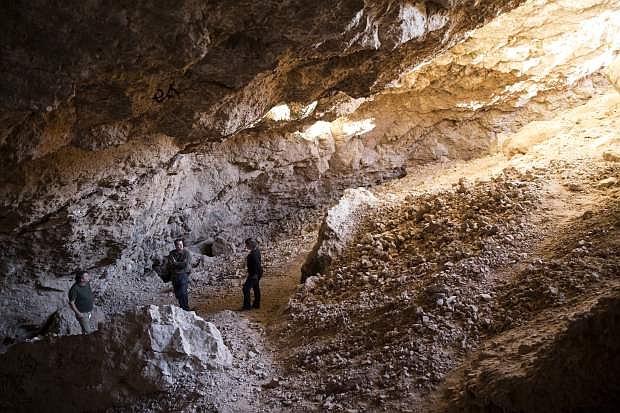 In this Tuesday, Dec. 19, 2017 photo, archaeologist Justin DeMaio, center, stands during a tour of the Gypsum Cave east of Las Vegas. A well-preserved horse skull collected more than 86 years ago from the cave near Las Vegas is helping scientists identify a new type of extinct, stilt-legged horse that died out during the last ice age. A team of researchers led by famed archaeologist Mark Harrington discovered the bone in the 1930s inside the Gypsum Cave. (Erik Verduzco/Las Vegas Review-Journal via AP)