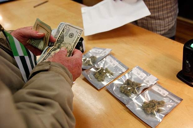 In this Jan. 1, 2018 photo, a customer purchases marijuana at Harborside marijuana dispensary in Oakland, Calif. Attorney General Jeff Sessions is going after legalized marijuana. Sessions is rescinding a policy that had let legalized marijuana flourish without federal intervention across the country. That&#039;s according to two people with direct knowledge of the decision. (AP Photo/Mathew Sumner)